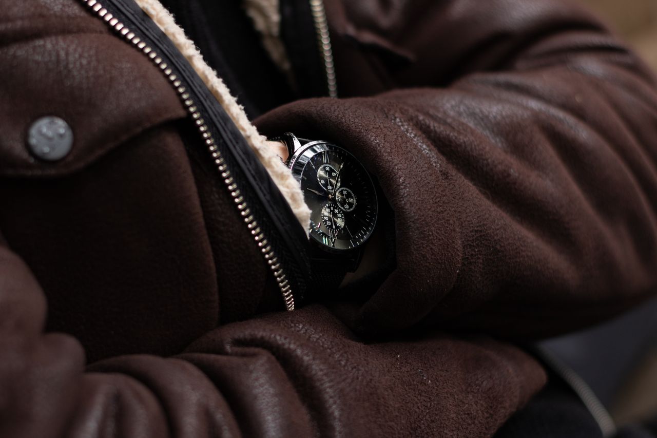 services-02 Close-up of a sophisticated wristwatch paired with a brown leather jacket. Perfect for fashion themes.