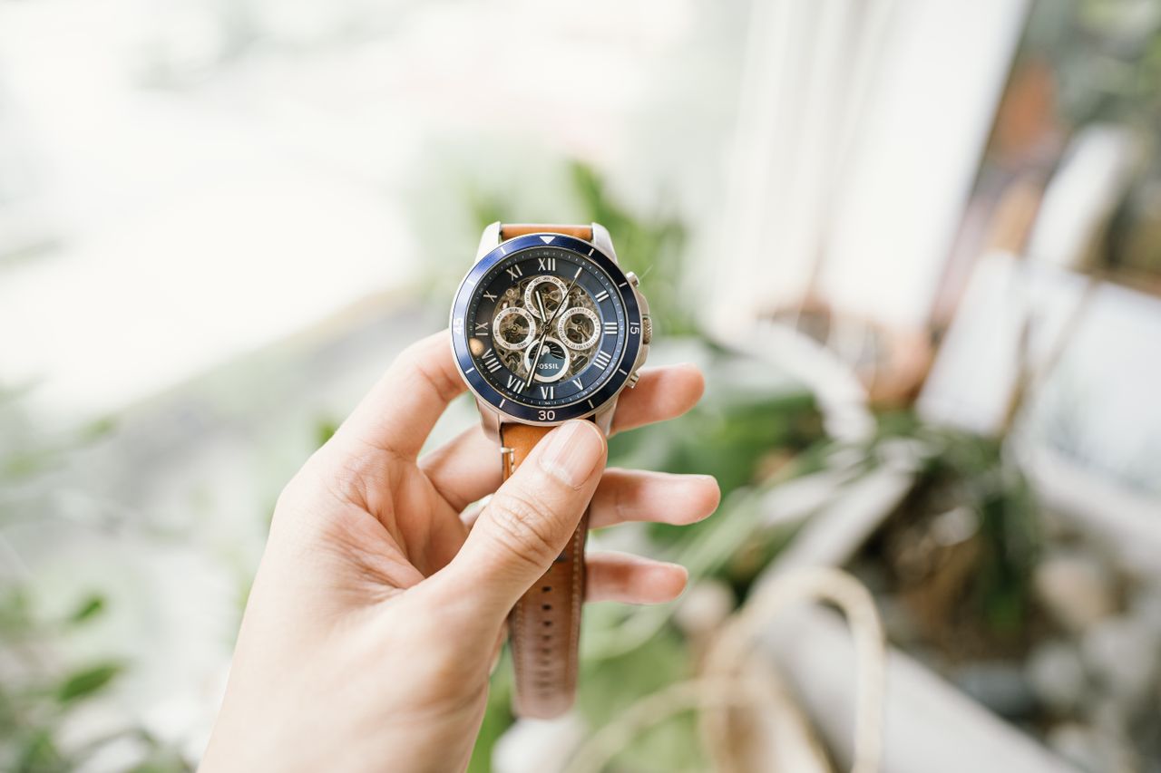 Best Watches For Men Under ₹10,000 in India — 2026 Edition A hand holding a sophisticated wristwatch with intricate gears, featuring a blurred background.